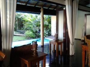 a living room with a view of a swimming pool at Villa Jati - Private Poolside Villa Central Lovina in Lovina