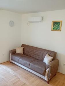 a brown couch in a living room with white walls at Walk to the Sea-1 bedroom BUDVA in Budva