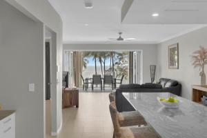 a kitchen and living room with a table and chairs at Seascape Solace - Breezy Waterfront Bliss in Palm Cove
