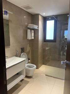 a bathroom with a shower and a toilet and a sink at Hawana salalah Forest island L3-G01 in Salalah
