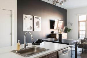 a kitchen with a sink and a black wall at Relaxed Elegance | Espadin LoHi in Denver +23 photos