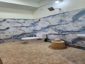 baño con pared de mármol, aseo y lavamanos en AK Residency, en Chennai