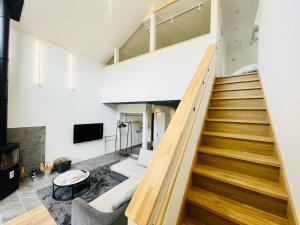 a living room with stairs leading up to a loft at Kinagashi Happo Chalet East in Hakuba