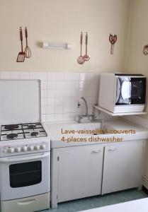 a kitchen with a white stove and a microwave at LOU FILADOUR 6 personnes 1er étage in Jausiers +25 photos