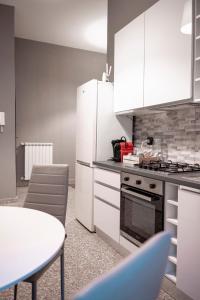 a kitchen with white appliances and a table and chairs at Il Nido del Falco Apartment in Castel Gandolfo