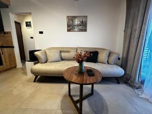 a living room with a couch and a table at Taca House - Airport apartman in Surčin