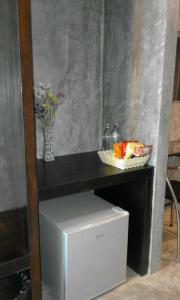 een tafel met een kom eten en een vaas met bloemen bij Come Moon Loft Hotel in Phrae