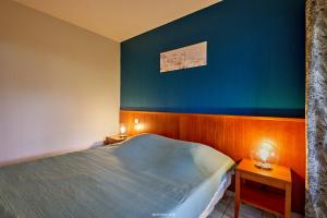 a bedroom with a bed and a blue wall at Appartement entre lac et océan in Carcans +13 photos