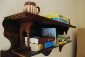 a book shelf with books and a stack thereof at Ferienwohnung Braunschweiger Hof in Halberstadt