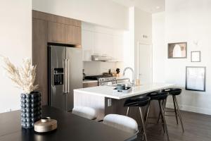 a kitchen with a refrigerator and a counter with stools at Relaxed Elegance | Espadin LoHi in Denver