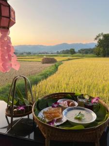 a table with food in front of a rice field at Chomdoi Villa in Ban Samai (2)