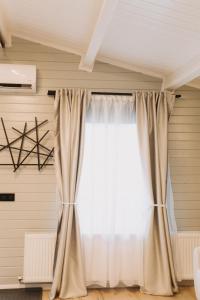 a window with curtains in a room at Szépasszony Guest House in Vlăhiţa +87 photos