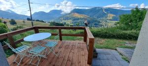 a wooden deck with two chairs and a table on it at Studio des cimes in Bussang