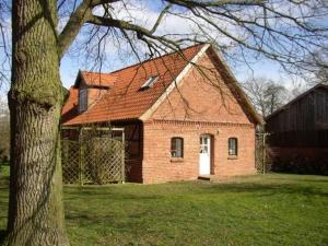 a red brick house with a white door and a tree at Fewo Elbtalaue "Dat-Goepelhus" in Neu Garge