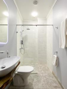 a white bathroom with a toilet and a sink at Keremet Hotel in Almaty +52 photos