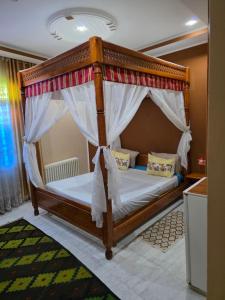 une chambre avec un lit à baldaquin dans une pièce dans l'établissement Maison D'hôte Dar Saida, à Sicca Veneria