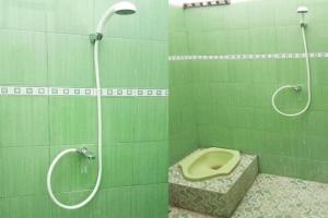baño verde con aseo y ducha en SPOT ON 3605 Clarichie Guest House, en Kupang 98 fotos más