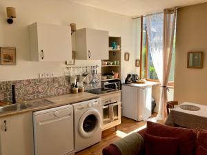 a kitchen with a washing machine and a washer at L Henri in Oloron-Sainte-Marie