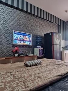 Una habitación con una cama grande y una nevera. en OYO 94024 Sentraland karawang By Aswin, en Poponcal 2