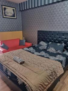 Un dormitorio con una cama y un sofá rojo. en OYO 94024 Sentraland karawang By Aswin, en Poponcal 2