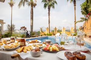 a table topped with plates of food next to a pool at Eagle View Golf in Kigali