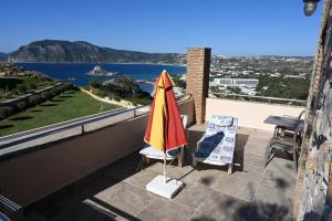 a patio with an umbrella and two chairs on a balcony at Panorama Studios in Kefalos