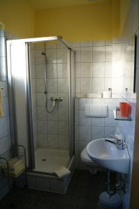 ein Bad mit einer Dusche, einem WC und einem Waschbecken in der Unterkunft Gasthof & Pension Palmenhof in Leegebruch