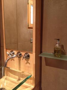 a bathroom with a sink and a bottle of soap at Lakeview 180° in Talloires