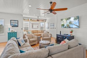 a living room with a couch and a ceiling fan at Eleventh Street in Mustang Beach