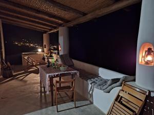 a table and chairs on a balcony at night at Casa Chiara, terrace with sea view in Malfa
