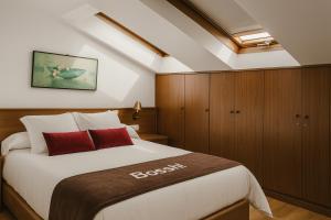 sypialnia z dużym łóżkiem i drewnianymi szafkami w obiekcie Hotel Hórreo by Bossh! Hotels w Santiago de Compostela