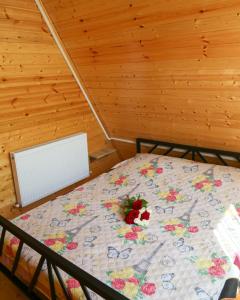 a bedroom with a bed with a flower quilt on it at Peradze Wine Cellar Vineyard Cottages in Khidistʼavi