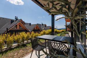a table and chairs on the patio of a house at Stylchyn Park - Czorsztyn Exclusive - by Upstairs in Kluszkowce