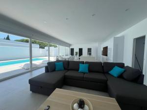a living room with a black couch and blue pillows at El Paraiso in Hozanejos
