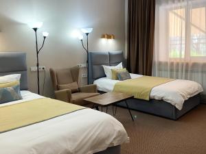 a hotel room with two beds and a chair at Keremet Hotel in Almaty +52 photos