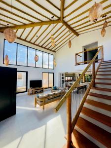 sala de estar amplia con escalera y sofá en Casa Surya - lux villa 5 min from center, en Itacaré