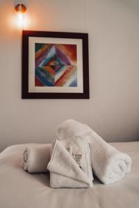 een handdoek op een bed met een schilderij aan de muur bij #15 Tallow Sands - The Cabin in Suffolk Park +8 foto's