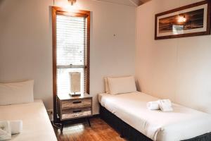 twee bedden in een kamer met een raam bij #15 Tallow Sands - The Cabin in Suffolk Park