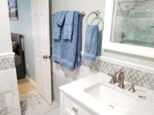 a bathroom with a sink and a mirror and blue towels at 206 on 10th St - All in Saint Augustine