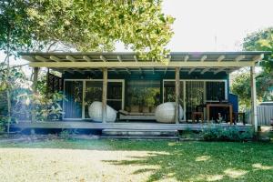 een blauw huis met een pergola in een tuin bij #15 Tallow Sands - The Cabin in Suffolk Park