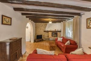 a living room with red couches and a fireplace at El Revolt de Martís in Esponellá