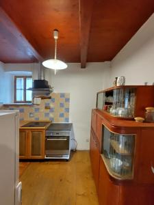 a kitchen with wooden cabinets and a stove top oven at Venkovský dům na kraji vsi in Kostelec nad Orlicí