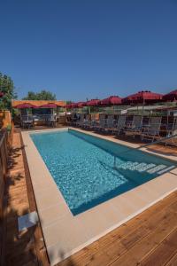 a large swimming pool with chairs and tables at Camping Girasole in Girasole