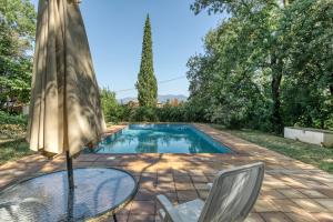 a pool with a table and chairs and an umbrella at El Revolt de Martís in Esponellá