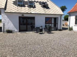 a house with a table and chairs in the yard at 4 star holiday home in Hornsyld in Hornsyld +18 photos