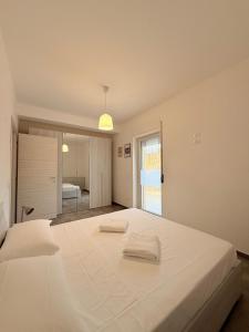 a white bedroom with a large bed with two towels on it at Dimora Bella Vista in LʼAquila