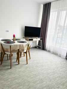 Una sala de estar con una mesa y un televisor. en Vladstudio, en Turda