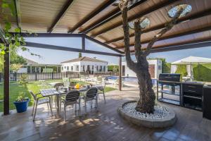 un patio con albero, tavolo e sedie di Casa rural Buhaira a La Puebla de Cazalla