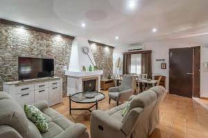 un soggiorno con divano e camino di Casa rural Buhaira a La Puebla de Cazalla