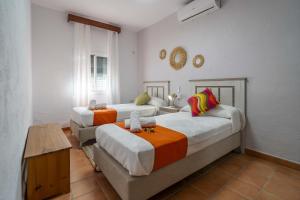 una stanza con tre letti e un tavolo di Casa rural Buhaira a La Puebla de Cazalla Altre 42 foto